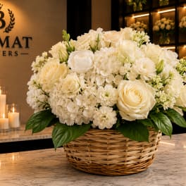 White rose and hydrangea arrangement in a wicker basket