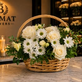 Basket arrangement of white roses and daisies with greenery