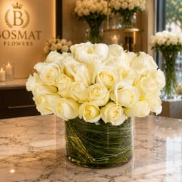 Creamy white roses arranged in a clear glass vase