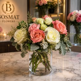 Pink and white rose bouquet in a clear glass vase
