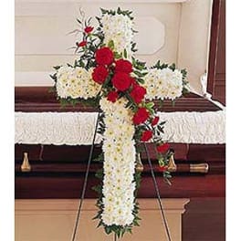 Floral cross on an easel with white and red flowers
