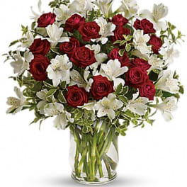 Red roses and white lilies in a clear glass vase