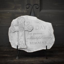 Decorative memorial plaque with a cross and engraved quote on a stand