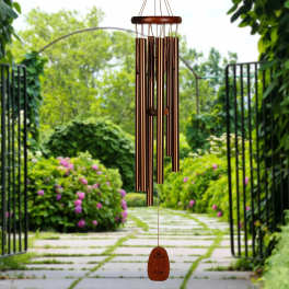 Copper wind chime hanging in a garden walkway