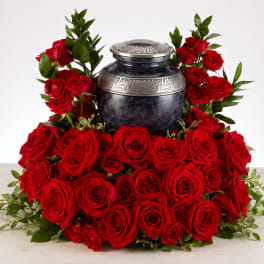 Red roses arranged around a decorative urn