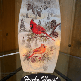 Decorative winter lantern with red cardinals and pinecones