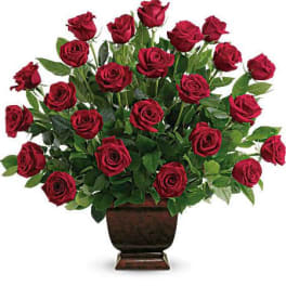 Red roses arranged in a dark urn vase