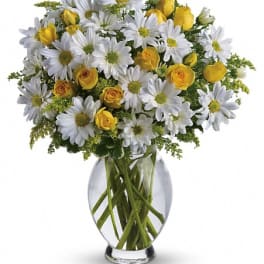 White daisies and yellow roses in a clear glass vase