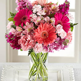 Pink and coral mixed bouquet in a clear glass vase