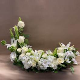 White floral casket spray with roses and lilies