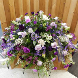Large purple and white floral spray with ribbon accents