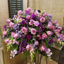 Large pink and purple floral spray with roses and mixed blooms