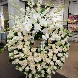 Large white floral standing spray with roses and orchids