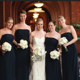 Bride and bridesmaids holding white rose bouquets