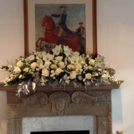 Large white floral arrangement displayed on a mantel