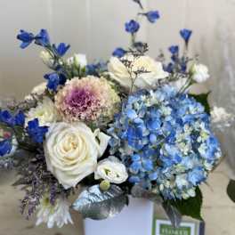 Blue and white floral arrangement in a white box