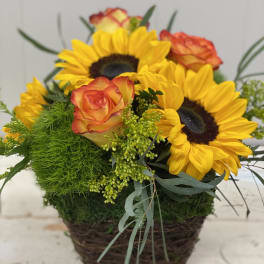Sunflowers and orange roses in a wicker basket