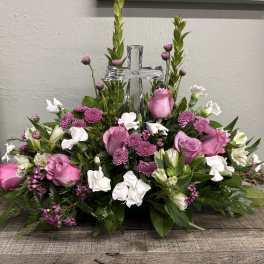 Pink and white floral arrangement with a clear cross centerpiece