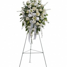 White floral standing spray on an easel with ribbon streamers