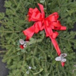 Green wreath with a red bow and small pinecones