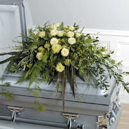 White rose casket spray with trailing greenery
