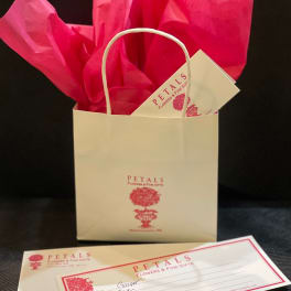 Gift bag with tissue paper and a floral gift card