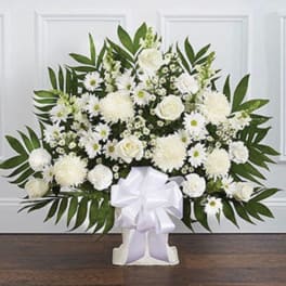 White floral standing spray with a large white bow on a stand