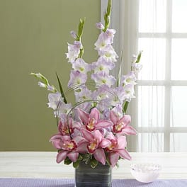 Pink and lavender orchids in a square glass vase