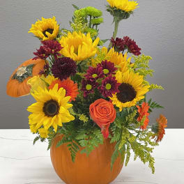 Sunflower and chrysanthemum arrangement in a pumpkin container