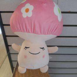 Plush pink-capped mushroom toy with a smiling face and flower spots on top.