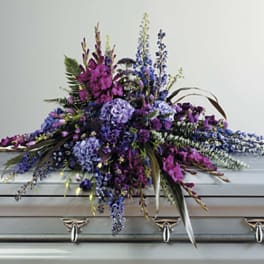 Purple and blue floral casket spray with long trailing stems