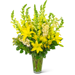 Yellow lilies and snapdragons in a clear glass vase