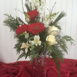 Tall floral arrangement with red gerbera daisies, white blooms, and a red vase
