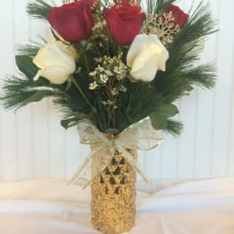Bouquet of red and white roses in a gold vase with a ribbon