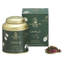 Green tea tin and box with floral accents beside loose tea leaves