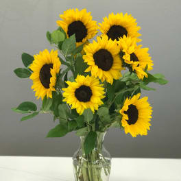 Bouquet of yellow sunflowers in a clear glass vase