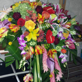 Large colorful floral spray with lilies, roses, and orchids