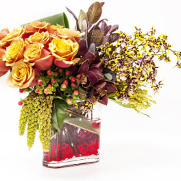 Bouquet of orange and yellow roses in a glass vase