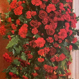 Tall standing spray of red roses and carnations with greenery