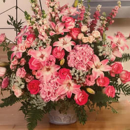 Large pink floral arrangement in a decorative vase