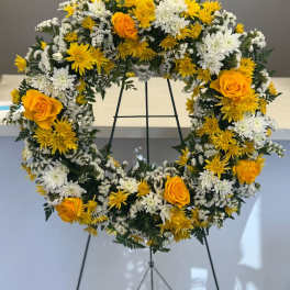 Yellow and white floral wreath on a black stand