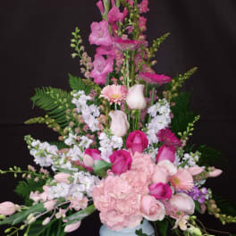 Tall pink and white floral arrangement in a white vase