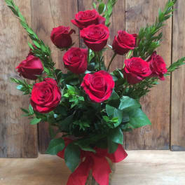 Bouquet of red roses in a clear glass vase with a red ribbon