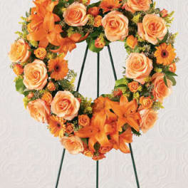 Orange floral heart wreath on a black stand