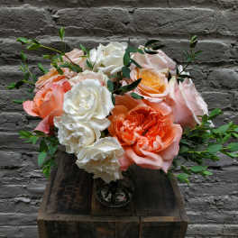Bouquet of peach, pink, and white roses in a glass vase
