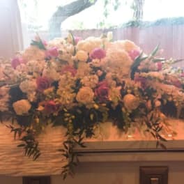Large floral spray on a casket with pink and white flowers