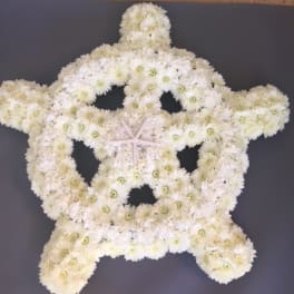 White floral arrangement shaped like a starfish on a dark background