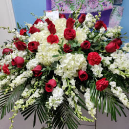Large red rose and white floral arrangement with cascading greenery
