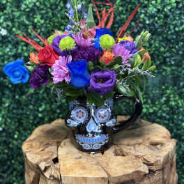 Colorful bouquet in a black skull mug on a wooden stand