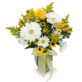 Bouquet of white daisies and yellow roses in a glass vase with a ribbon